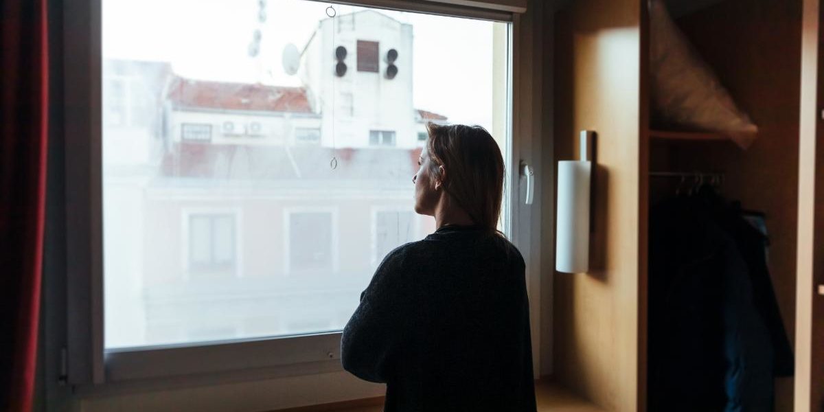 Exercise Addiction Replacing One Addiction With Another a woman looking out a window thinking about exercise addiction replacing one addiction with another