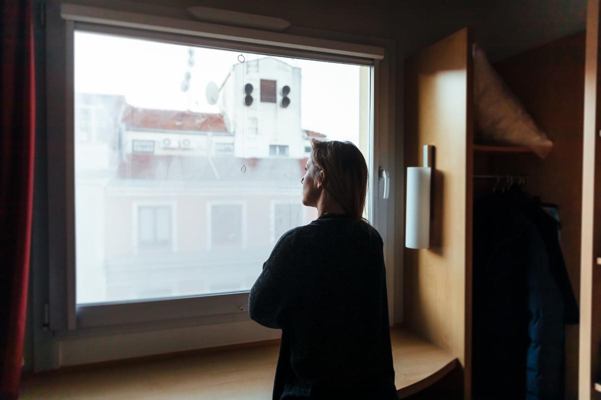 a woman looking out a window thinking about exercise addiction replacing one addiction with another