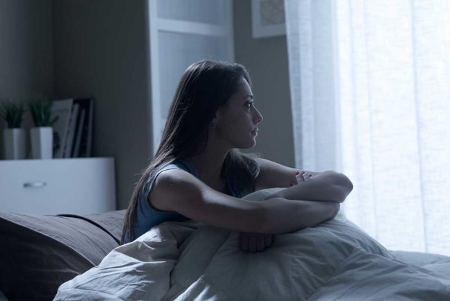 woman in bed wondering how to get off heroin