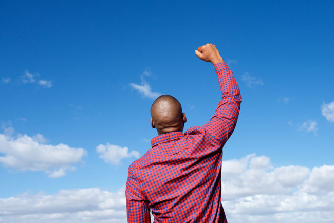 recovery definition, a man with his fist in the air after successful recovery