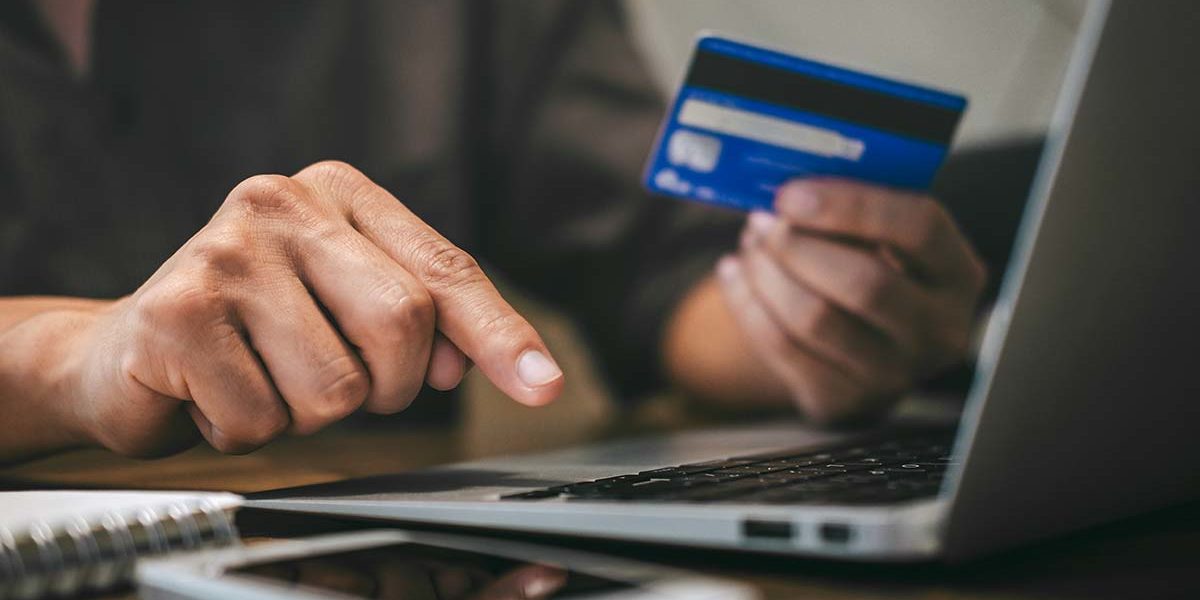 person entering credit card information on laptop to find out how much is detox compared to college