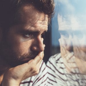 Sad man reflected in a window contemplated his drug abuse definition.