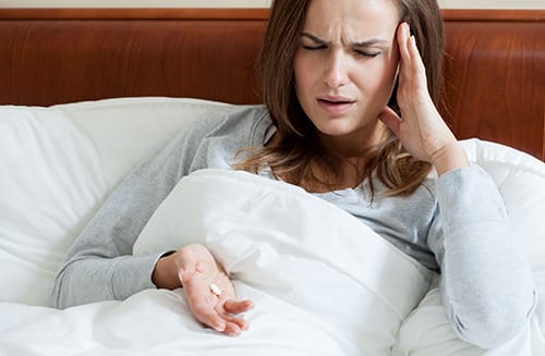 Hydrocodone side effects include headache like this woman is experiencing
