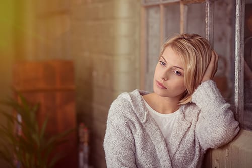 Depressed woman on sofa struggling with alcohol abuse and what to do about it.