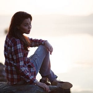 Young woman sitting outside ready to learn how to detox safely.