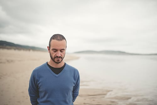 Man walking on beach at a quality men's alcohol detox in Florida