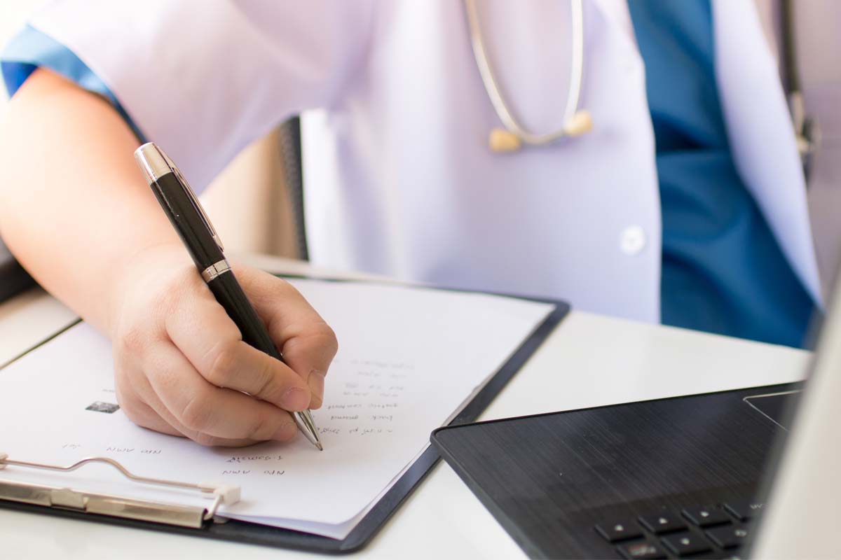 close up of doctor writing a note for a patient explaining, what is cirrhosis