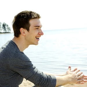 Smiling man on beach after inpatient drug rehab in Florida.