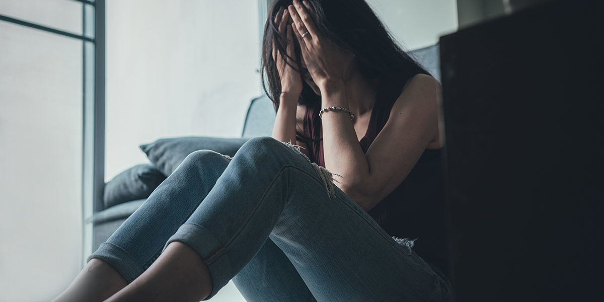 woman covering her face going through detox for meth