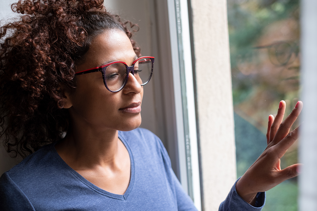 a woman looking out the window thinking about stages of alcoholism