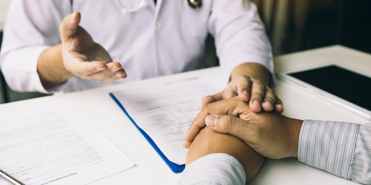Benefits of a Percocet Detox in Florida a man's hands on a table as he talks to his doctor about percocet detox in florida