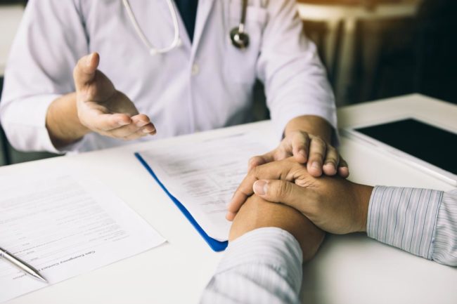 a man's hands on a table as he talks to his doctor about percocet detox in florida