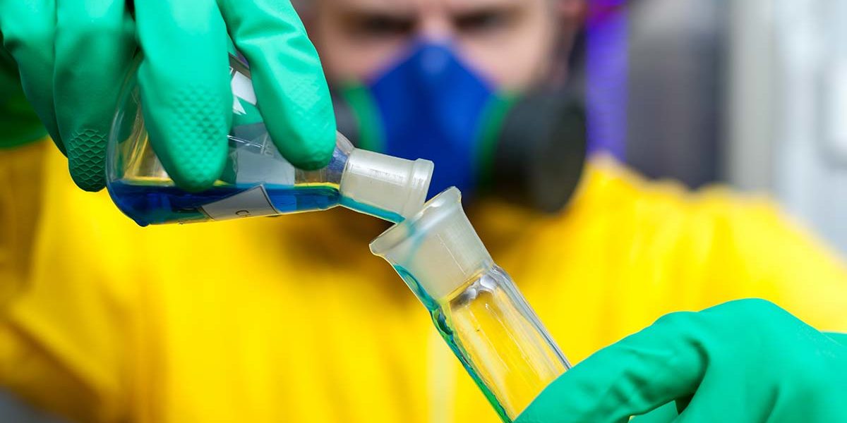 man in hazardous protective gear pouring a mixture to made drugs adding to designer drugs addiction