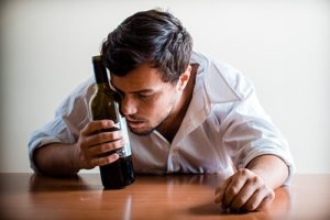 Guy hugging bottle wants to know is alcohol a stimulant or depressant