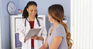 Medical staff member at detoxification center speaking to female patient