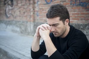 Depressed man with hands to head needs chemical dependency treatment in Florida