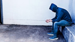 Man on concrete in the middle of the meth withdrawal timeline