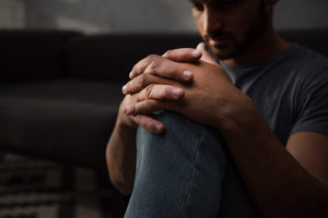 Man in dark wondering about methadone and suboxone for opioid addiction recovery