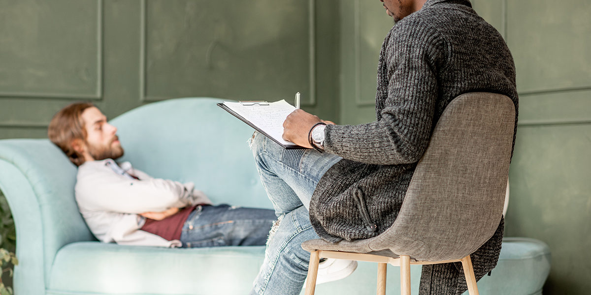 man laying on couch talking to therapist at medical detox centers in colorado