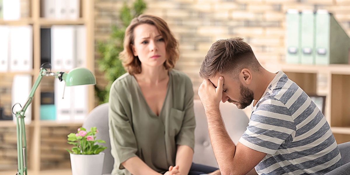 man sitting down with his head in his hands while he talks to a therapist taking advantage of the services offered at one of the mens drug detox centers ft lauderdale