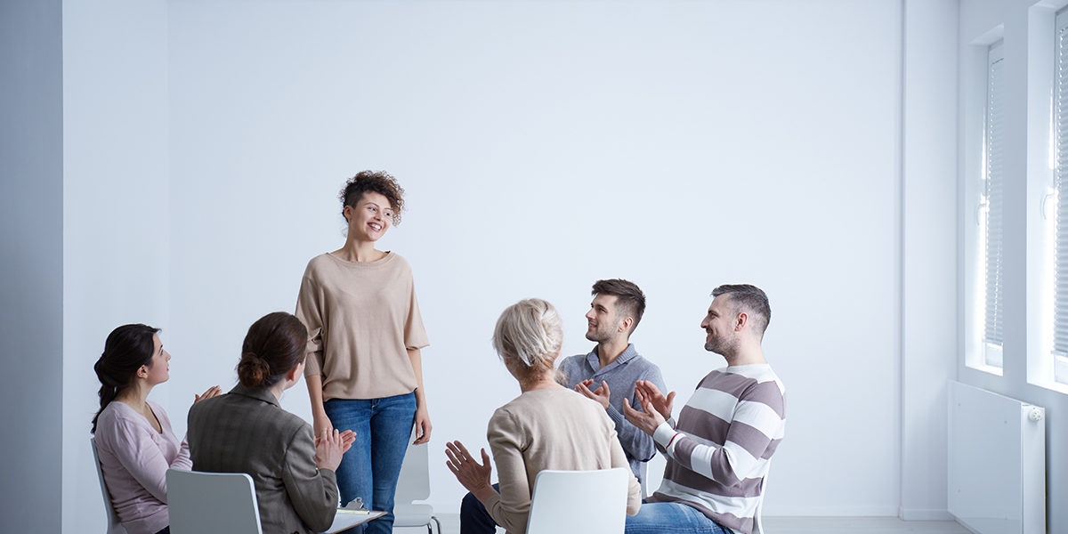a group therapy session asking how long does rehab last