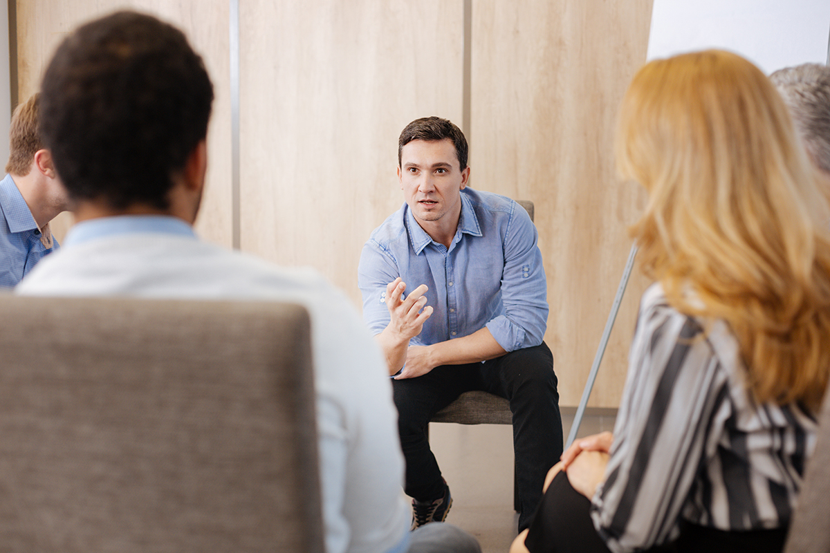 a group therapy session talking about trauma therapy techniques