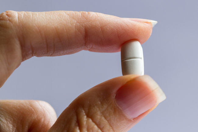 a person looking at a pill wondering what is codeine