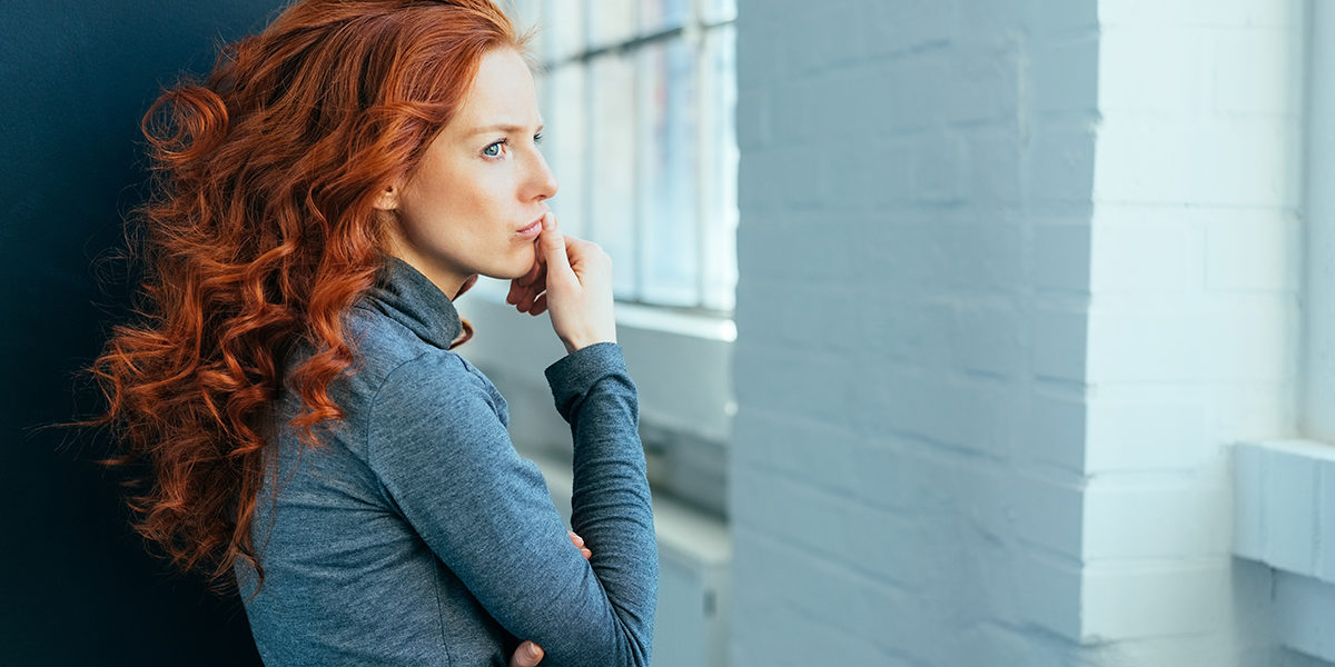 woman looking out the window wondering what is chronic relapse