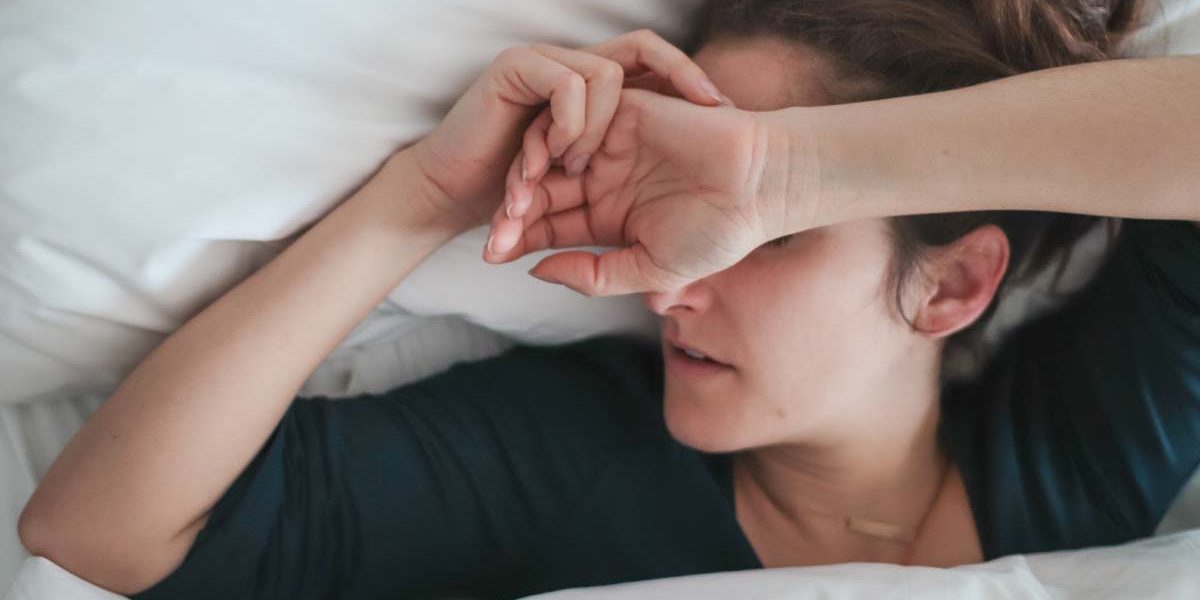 hungover women in bed thinks about the dangers of binge drinking
