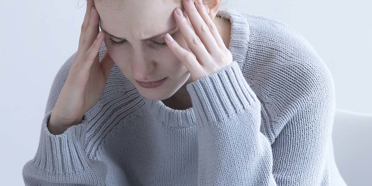 woman with headache struggling with the signs of ptsd