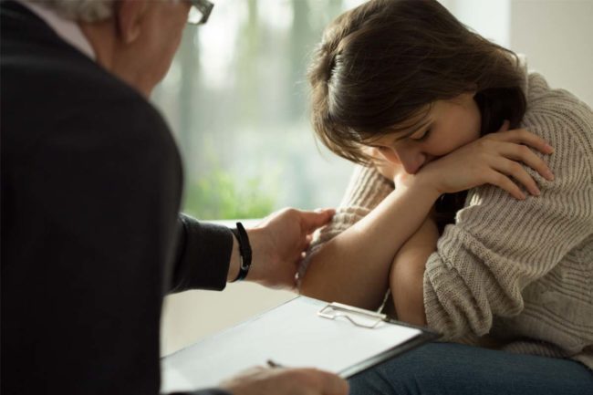 girl talking with therapist struggling with symptoms of anxiety