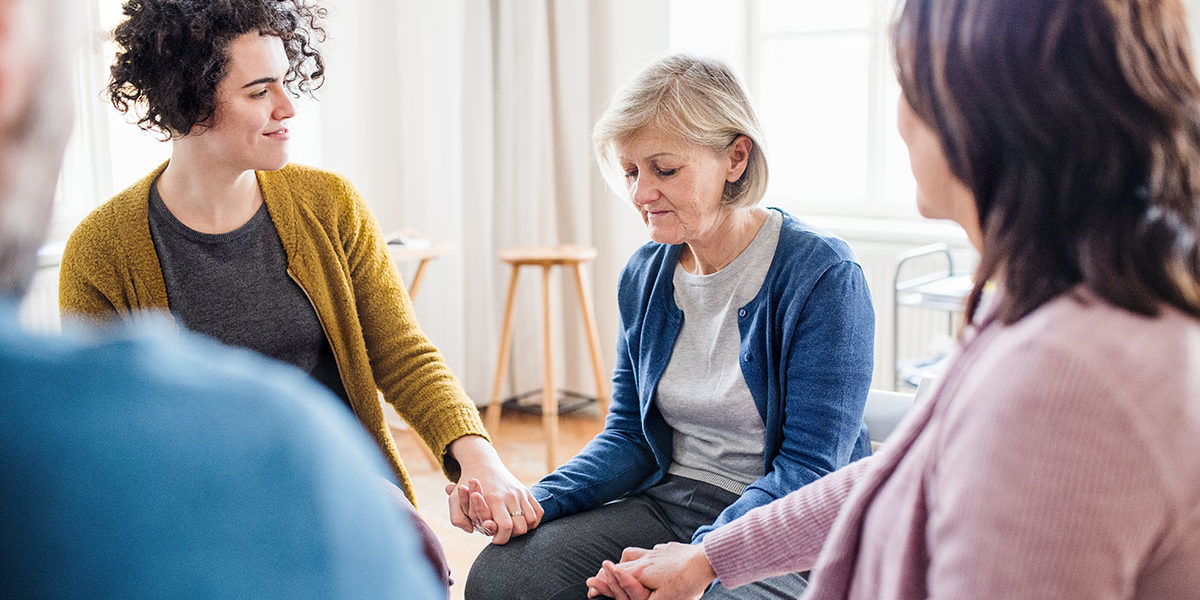 a woman holding hands at a steps to recovery meeting