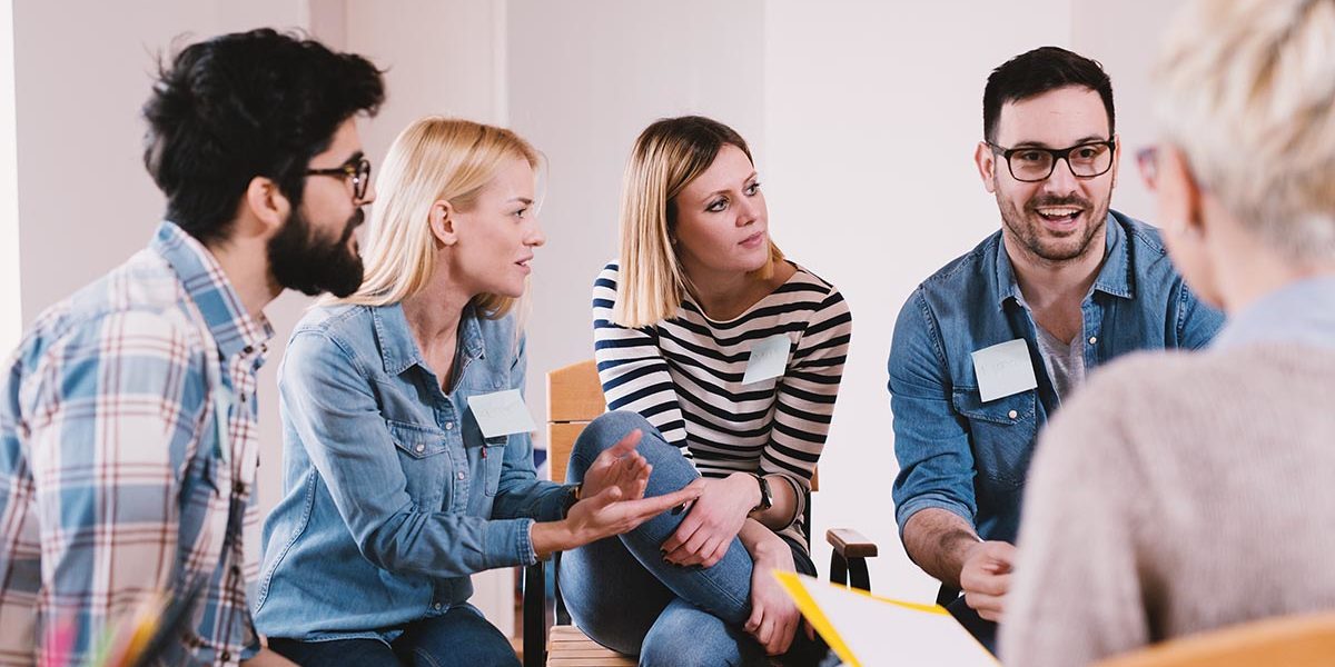 a session leader explaining the benefits of group therapy