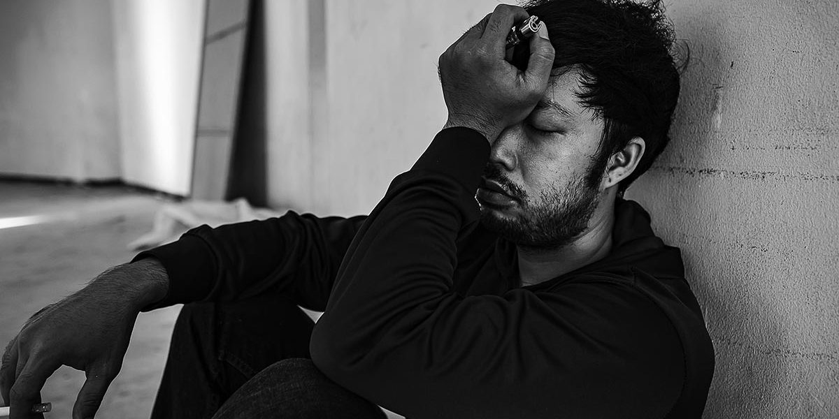 a man distressed as he experiences dangers of substance abuse