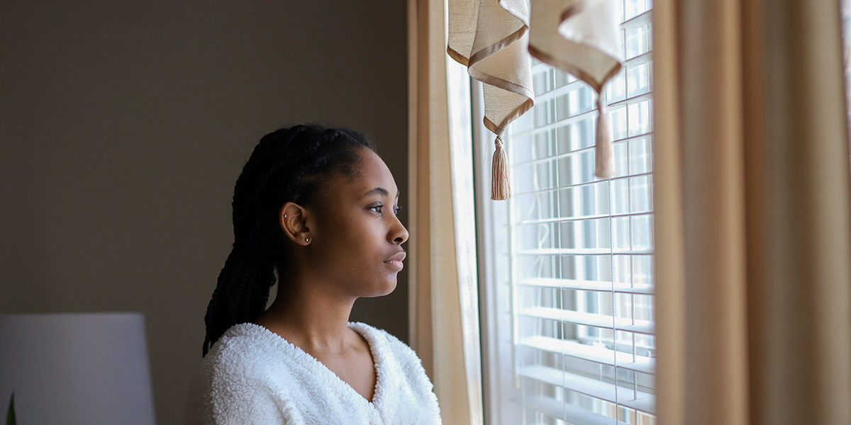 a woman looking out of her window wondering how to stop drug abuse