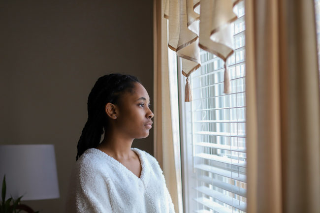a woman looking out of her window wondering how to stop drug abuse