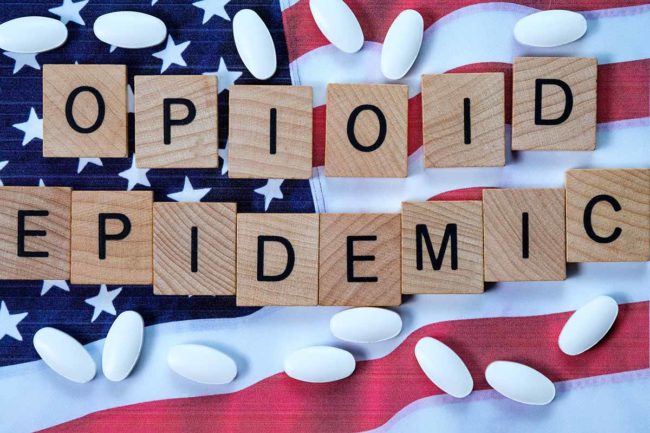 a flag and pills illustrating the opioid epidemic 2019