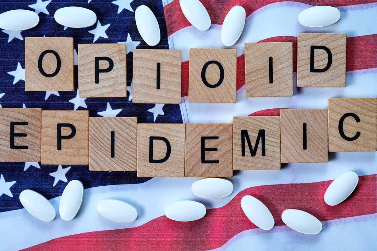 a flag and pills illustrating the opioid epidemic 2019