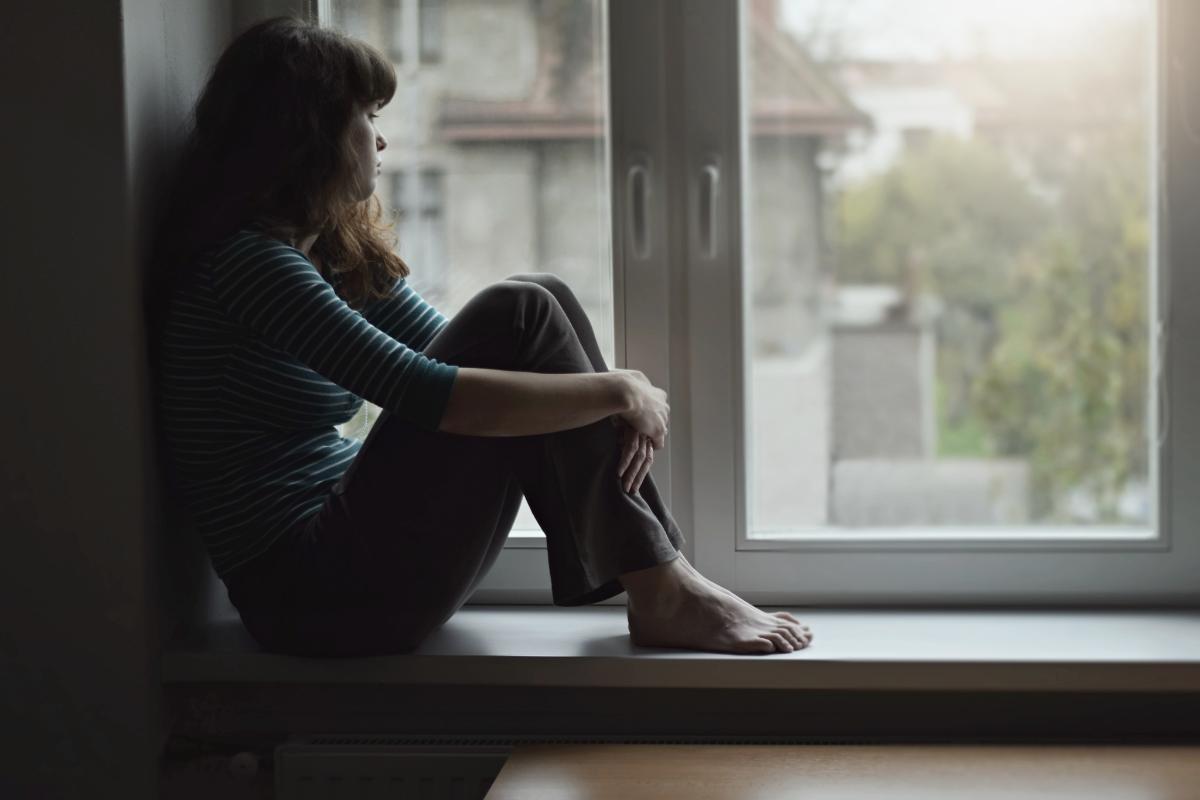 a woman looking out her window struggling with bipolar disorder and addiction