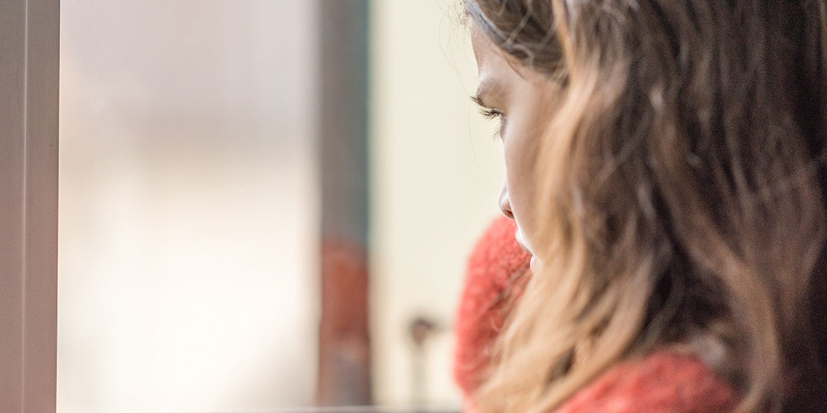 a woman looking out the window of a Newark Alcohol Detox