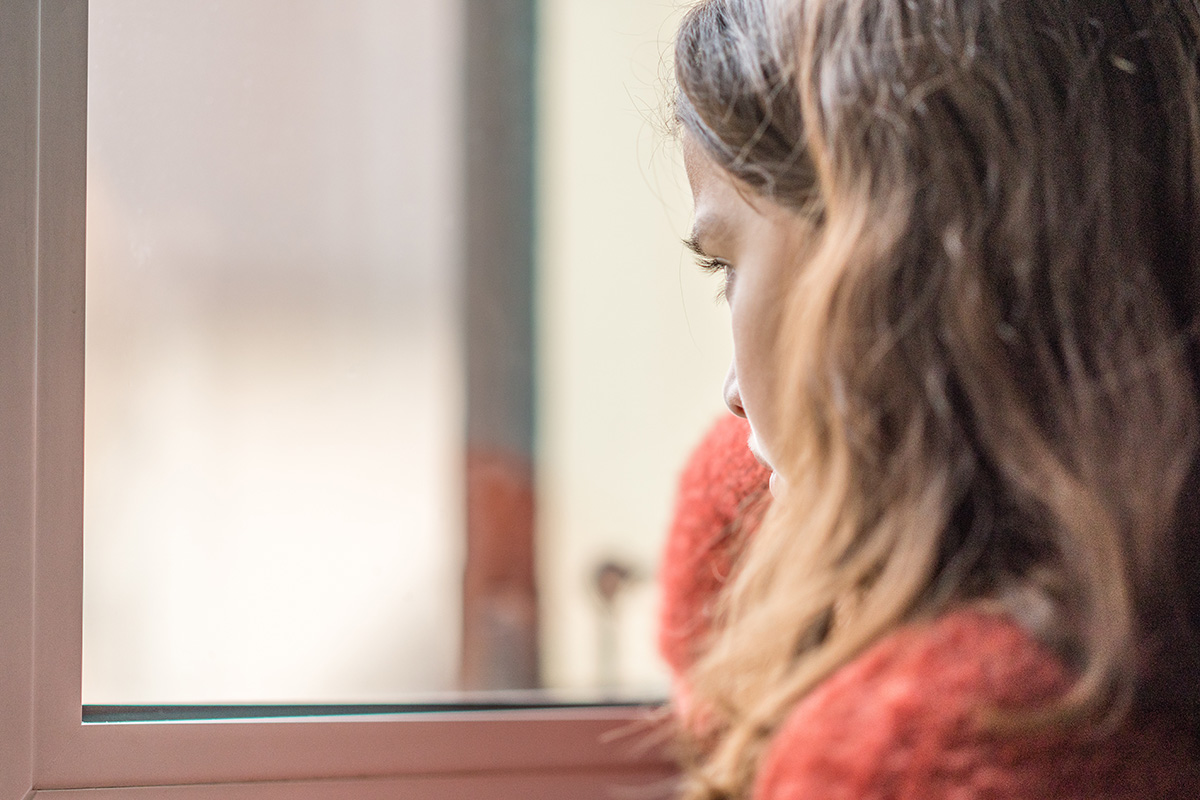a woman looking out the window of a Newark Alcohol Detox