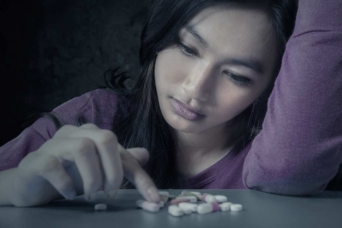 woman suffers from the early signs of painkiller addiction