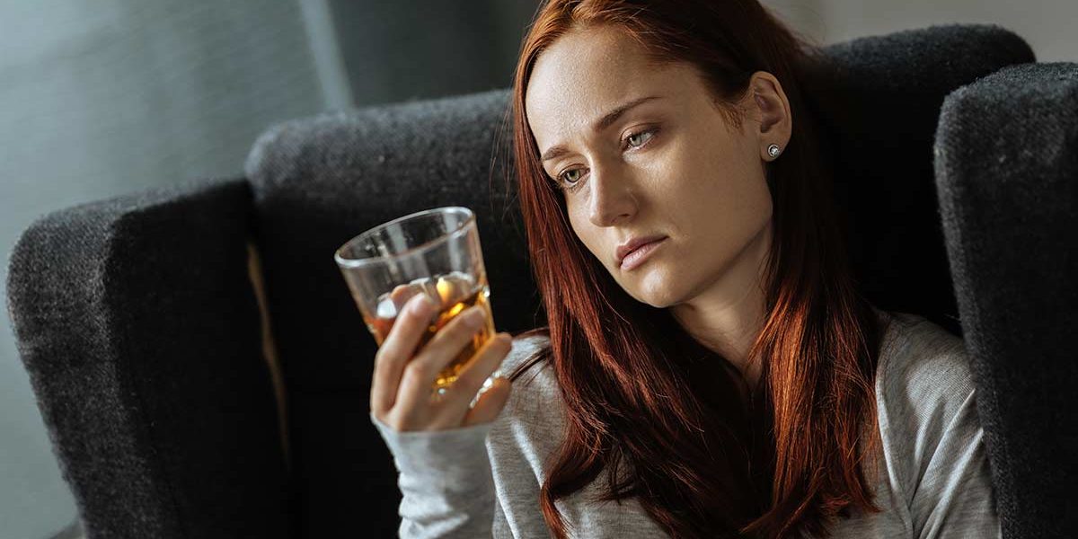 The Causes of Alcohol Addiction woman considers the causes of her alcohol addiction