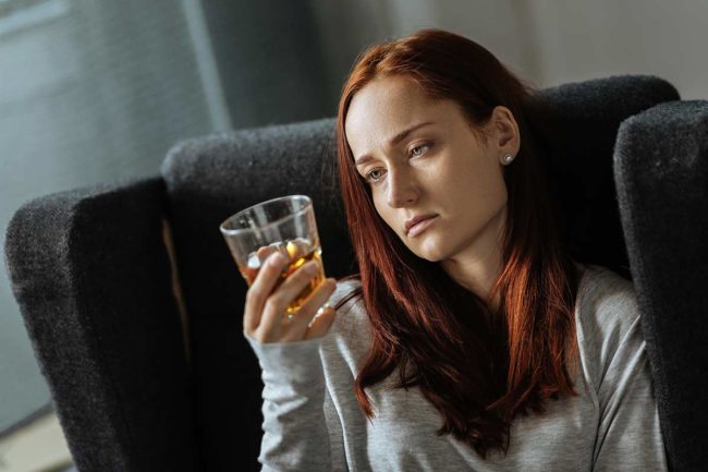 woman considers the causes of her alcohol addiction