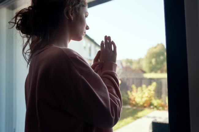 woman looking out her window thinking about tips for controlling a meth relapse